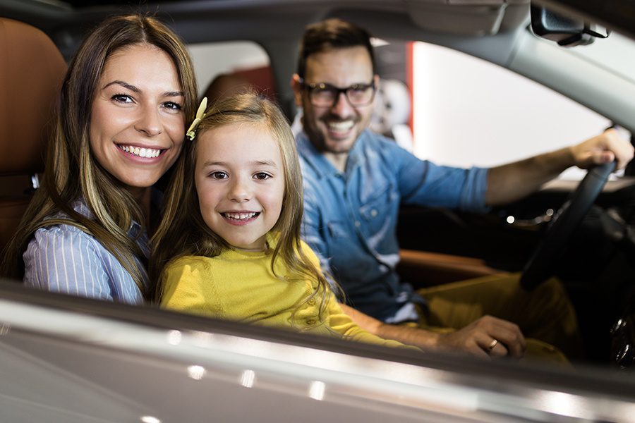 Personal Insurance - Happy Family Buying a New Car at the Car Showroom