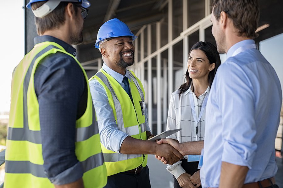 Specialized Business Insurance - Engineers and Architects in Conversation and Shaking Hands at Building Site